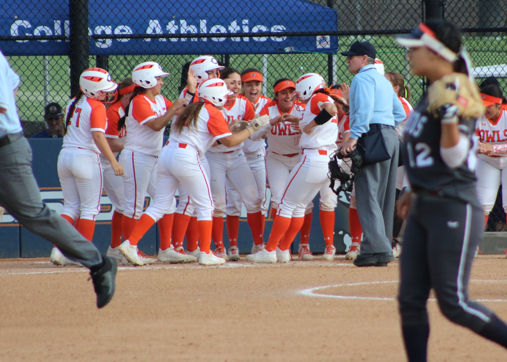 Alexis Acosta crosses home plate, much to the pleasure of her teammates. Image: Treyvon Watts-Hale